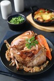 Tasty cooked rabbit meat with vegetables served on black table