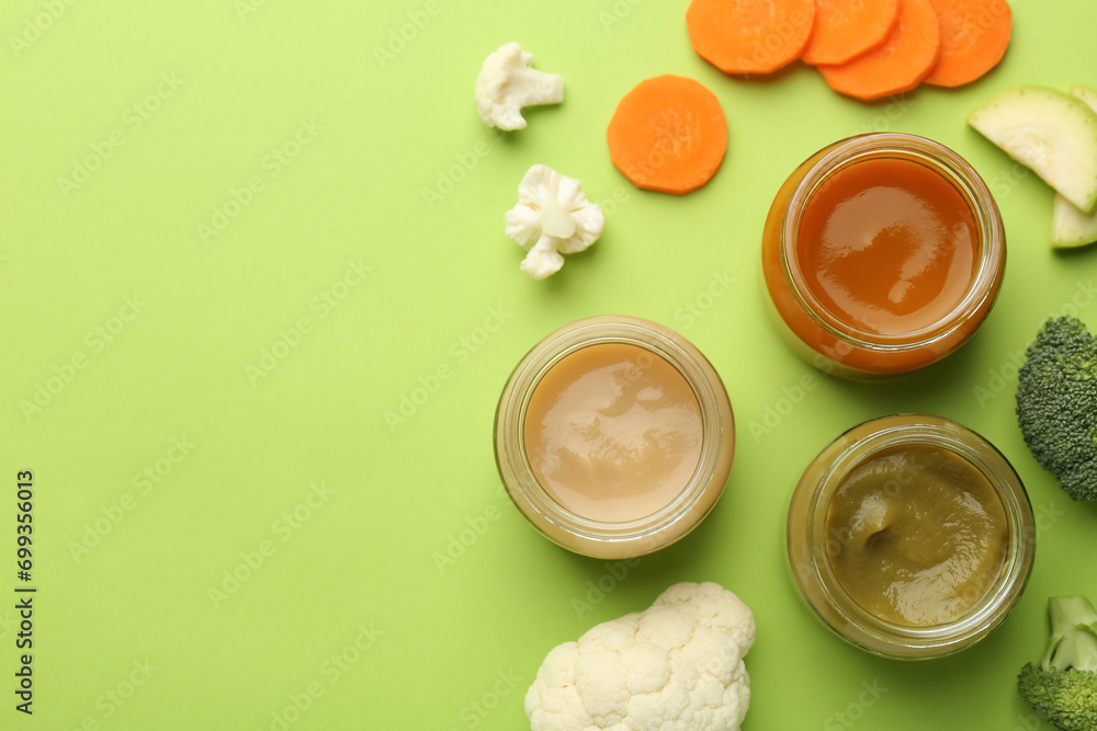 Jars with healthy baby food and fresh vegetables on light green background, flat lay. Space for text Jars with healthy baby food and fresh vegetables on light green background, flat lay. Space for text