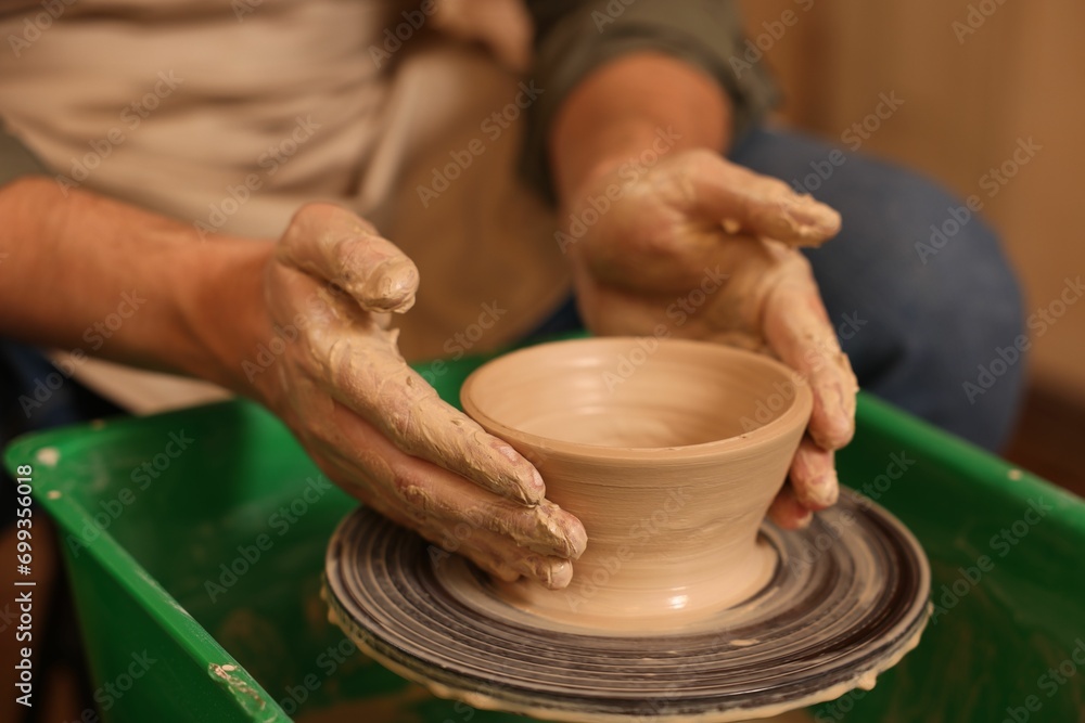 Clay crafting. Man making bowl on potter's wheel, closeup Clay crafting. Man making bowl on potter's wheel, closeup