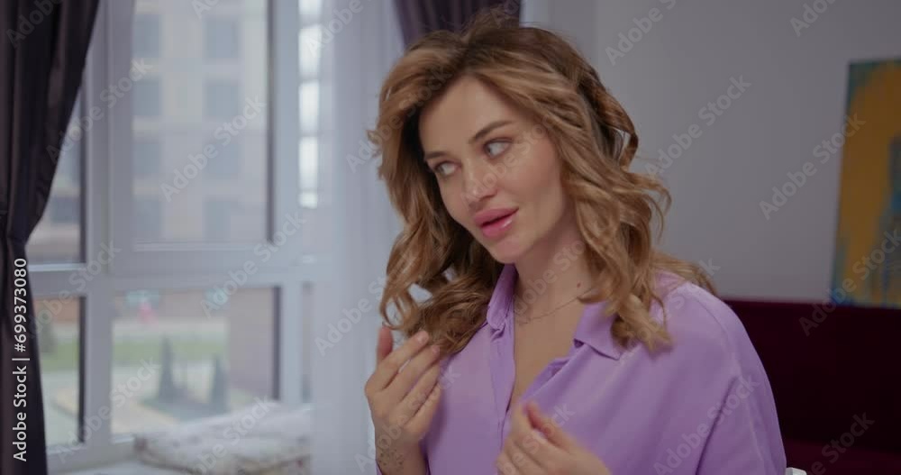 Beautiful young blonde girl touches her curls, adjusts her stylish hairstyle Beautiful young blonde girl touches her curls, adjusts her stylish hairstyle