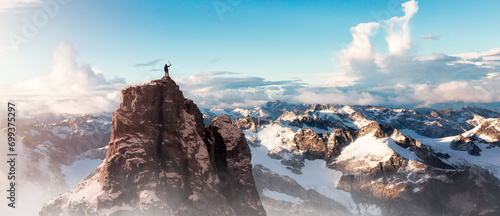 Adventure Man on top of Rocky Mountain Cliff. Aerial Canadian Mountain landscape from British Columbia