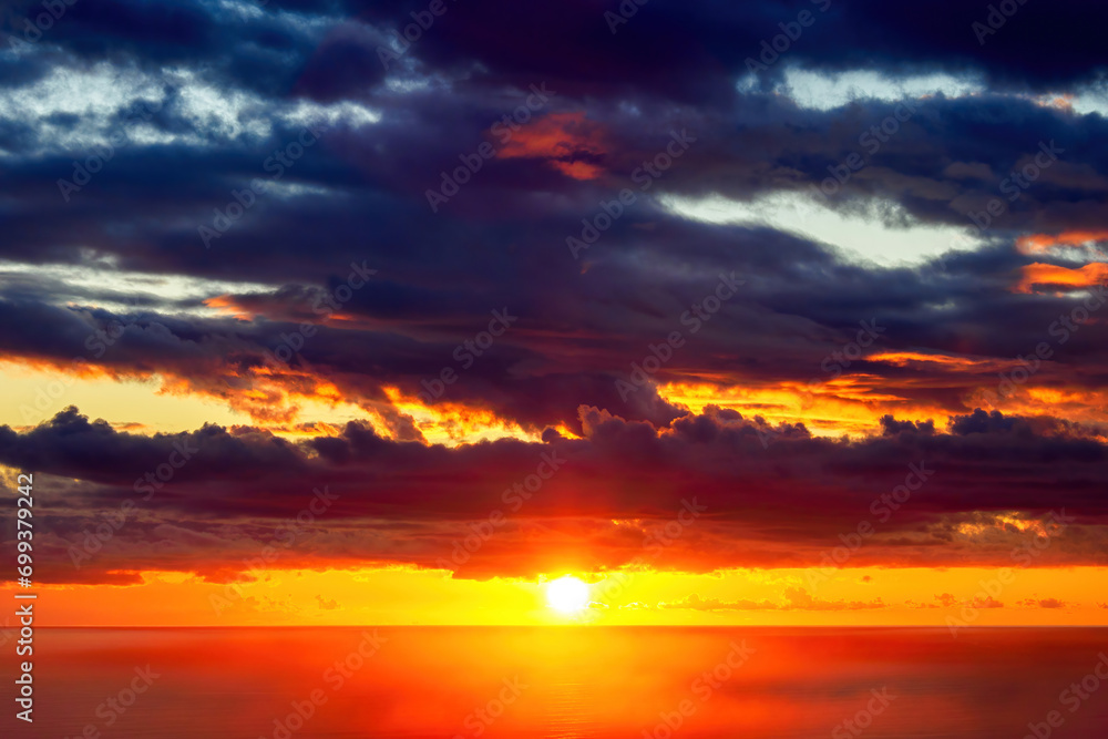 Sunset with dramatic clouds over Tasman sea at Piha beach, Auckland, New Zealand