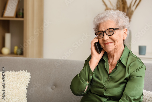 Tableau sur toile Senior woman talking by mobile phone at home