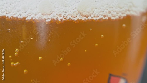 Amber colored carbonated beverage with bubbles rising to the surface.
