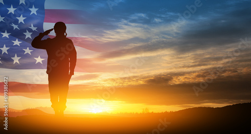 Fototapeta Naklejka Na Ścianę i Meble -  Silhouette of soldier saluting on background of sunset or sunrise and USA flag. Greeting card for Veterans Day, Memorial Day, Independence Day. America celebration.