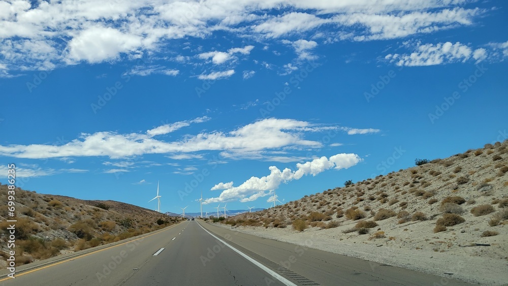 Fototapeta premium Interstate-8 highway running thru a wind corridor with electric windmills in the distance, San Diego County, Southern California