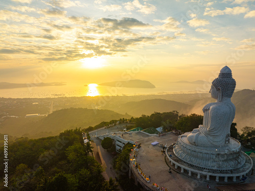 Aerial view The golden sun shines through the clouds above the ocean at the Big Buddha...bright yellow sun ray shine on the head of Phuket big Buddha. ..The sun's rays were peeking through the clouds.