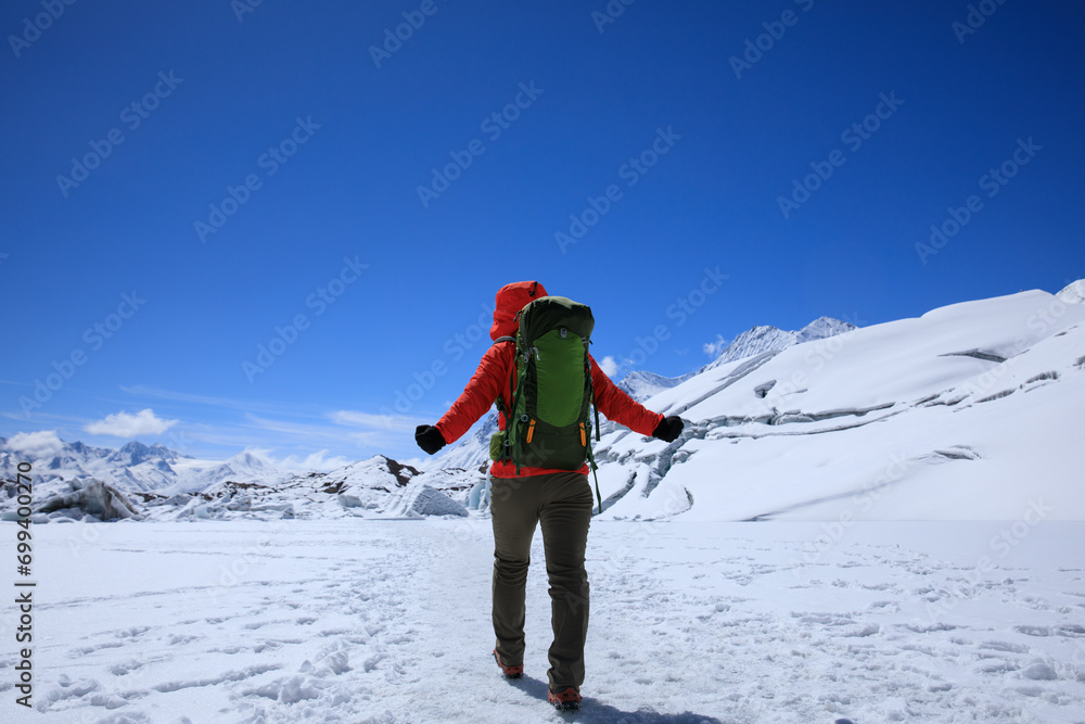 Woman hiker hiking in winter huge glacier mountain,China