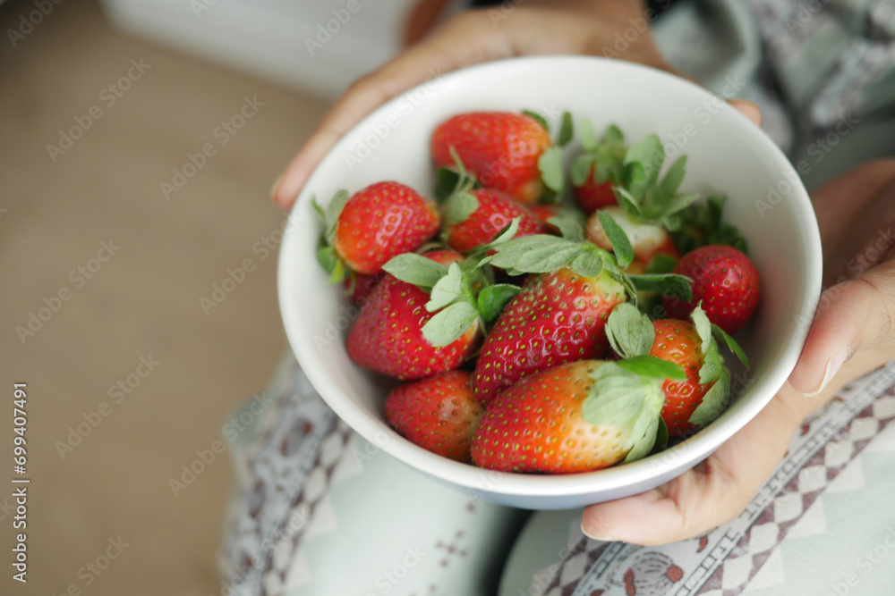 women holding a bowl or Ripe Red Strawberries women holding a bowl or Ripe Red Strawberries