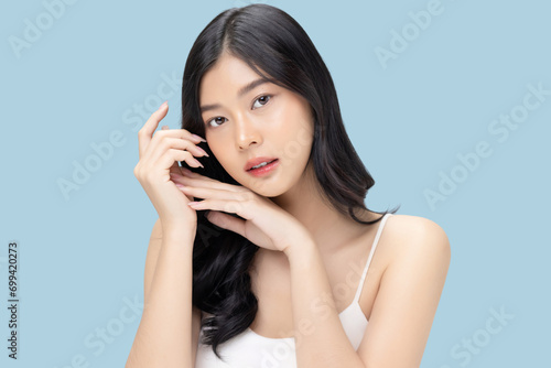 Beautiful young Asian woman with clean fresh skin isolated on blue background, Face care, Facial treatment, Cosmetology, beauty and spa.