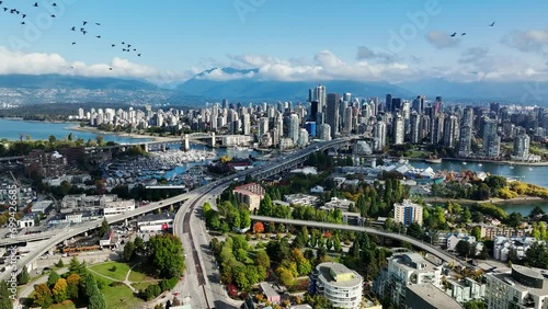 Flock Of Birds Flying Over South Granville With A View Of Downtown Vancouver And False Creek In Canada. - aerial shot photo