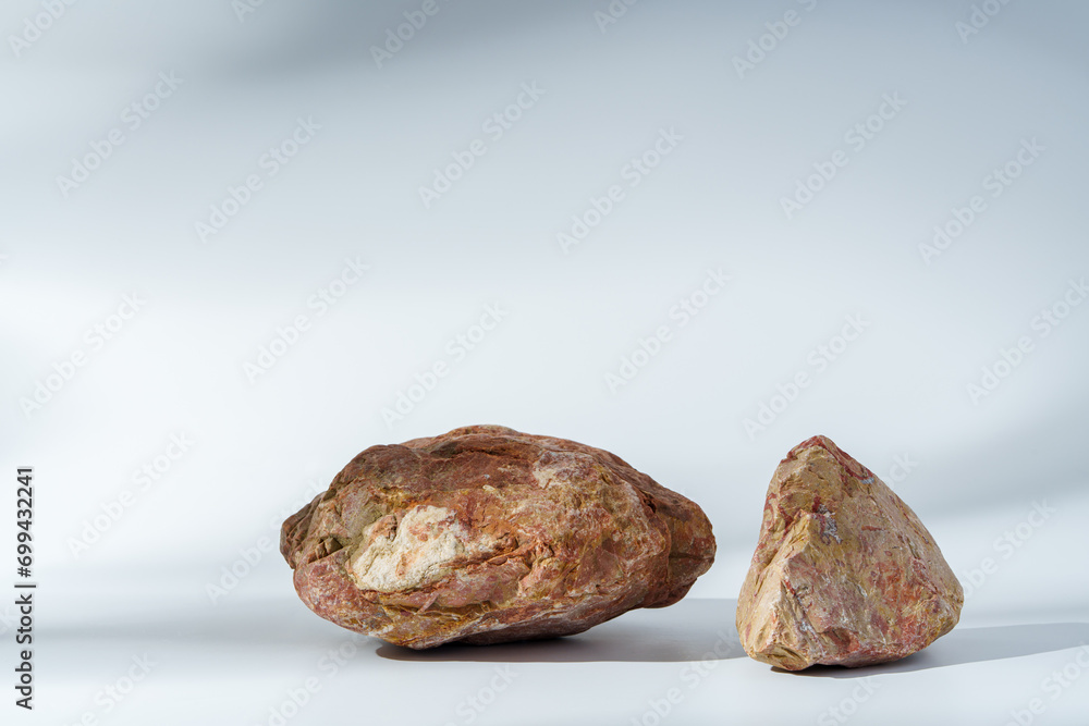 Piece of granite stone on white background with shadows Piece of granite stone on white background with shadows