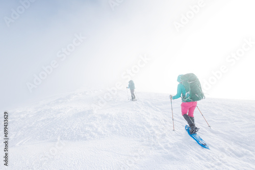 climbers climb the mountain. Winter mountaineering. two girls in snowshoes walk through the snow.