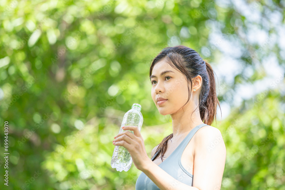Athlete young beautiful woman with a plastic bottle at green park, Sports woman drinking water after working out exercising Athlete young beautiful woman with a plastic bottle at green park, Sports woman drinking water after working out exercising