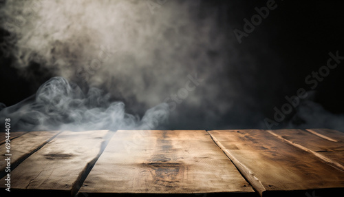 Old wood table with smoke in the dark background.