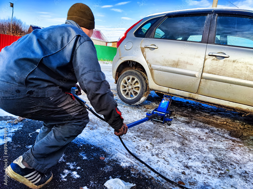 Ishim, Russia November 27, 2023 A man makes tire of car wheel before