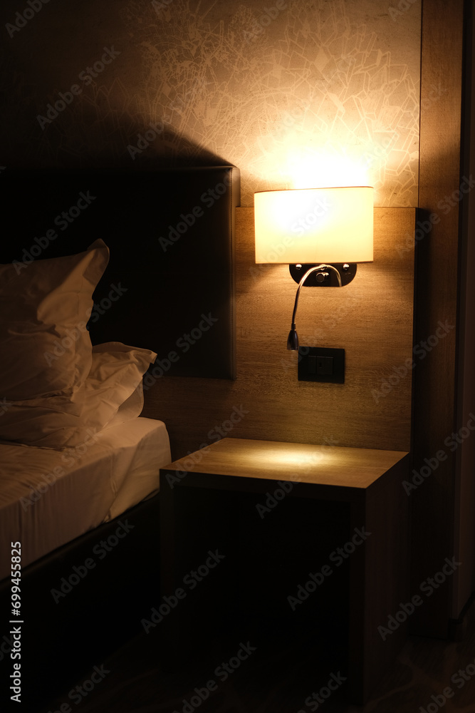 night light above the bed in a modern hotel room interior - obrazy, fototapety, plakaty 