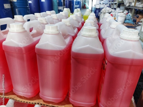 lots of white jerry cans filled with hand soap and sanitizer liquid in warehouse	