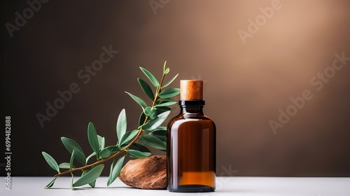 Eucalyptus essential oil in brown glass bottle on blurred background with green leaves and dropper photo