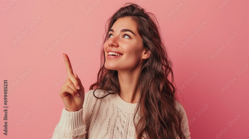 Optimistic Young Woman in Sweater Pointing Upwards on Pink Background Optimistic Young Woman in Sweater Pointing Upwards on Pink Background