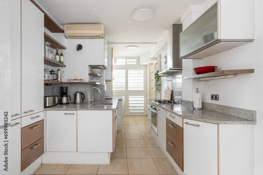 Fototapeta premium Kitchen zone equipped with cooking appliances and furniture