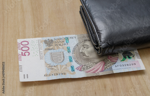 Polski banknot 500 pln leży na stole obok portfela