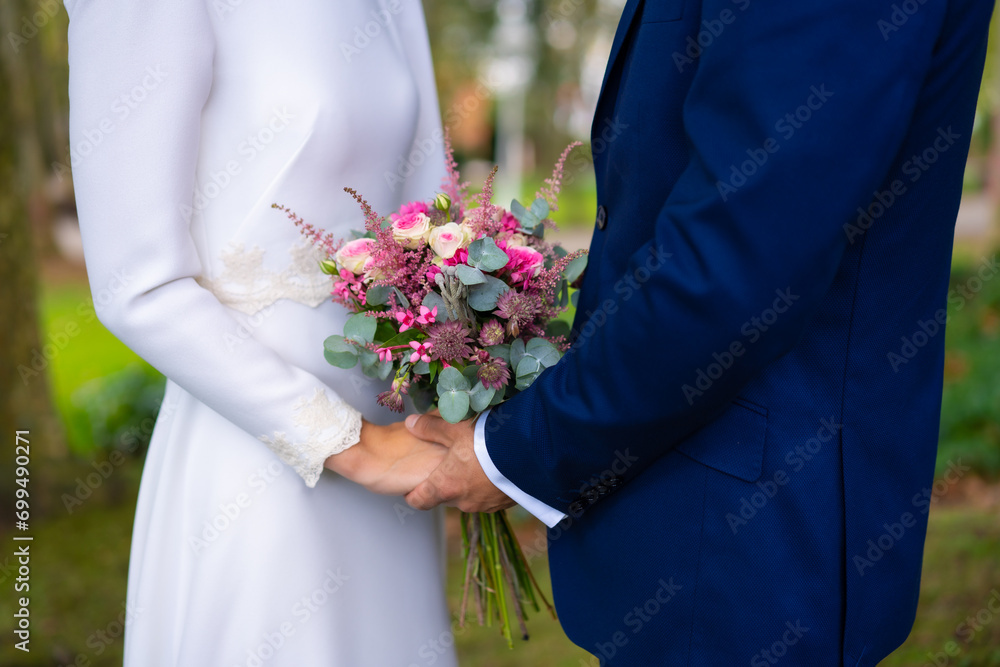 Detail of hands at the wedding of the happy bride and groom with flowers, marriage portraits Detail of hands at the wedding of the happy bride and groom with flowers, marriage portraits