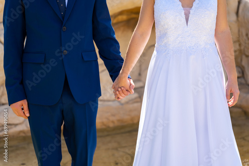 Bride and groom holding hands at the wedding of the happy bride and groom, marriage portraits