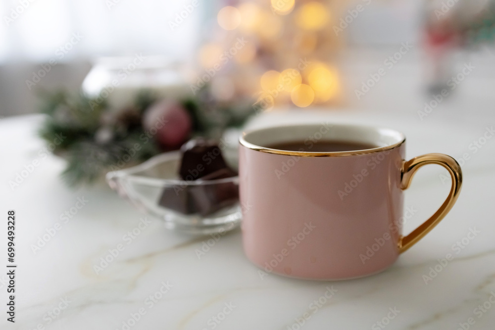 Pink cup with coffee and chocolate in a glass vase on the table. Bokeh. Photo Pink cup with coffee and chocolate in a glass vase on the table. Bokeh. Photo