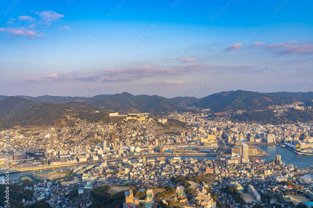 Nagasaki cityscape panorama view from Mt Inasa observation platform deck in sunny day sunset time with blue sky background, famous beauty scenic spot in the world. Nagasaki Prefecture, Japan