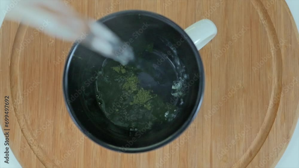 Close up shot of hot water added into ceramic cup with matcha powder Close up shot of hot water added into ceramic cup with matcha powder
