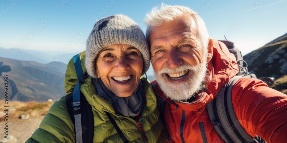 Happy smile elderly couple of hikers in the ascent to the summit take a selfie phone on the green highlands landscape around 
