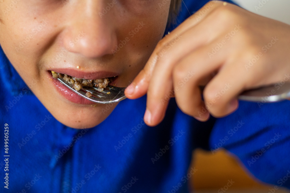 boy eats buckwheat porridge with a fork boy eats buckwheat porridge with a fork