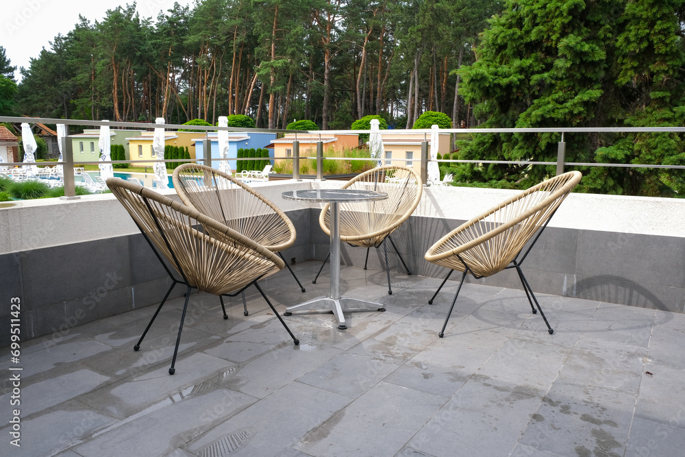 Fototapeta premium Balcony of a country cottage with a metal table and chairs.