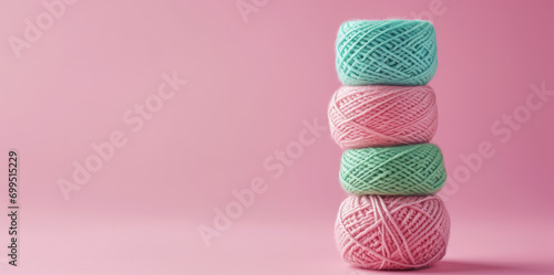 Skeins of warm woolen yarn in tangles in a delicate pastel color palette. Background for handmade and knitting store. Wallpaper with balls of yarn isolated on pink background with copy space.
