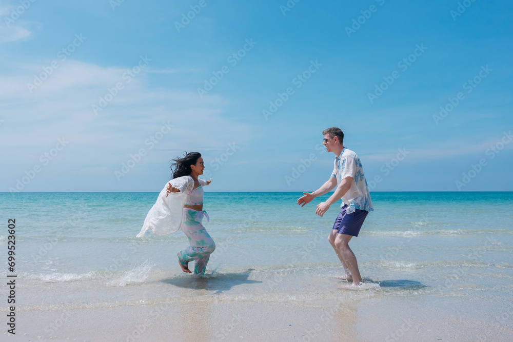Happy and loving young couple enjoying at tropical beach.  Couple Enjoying Fun and Romance by the Ocean