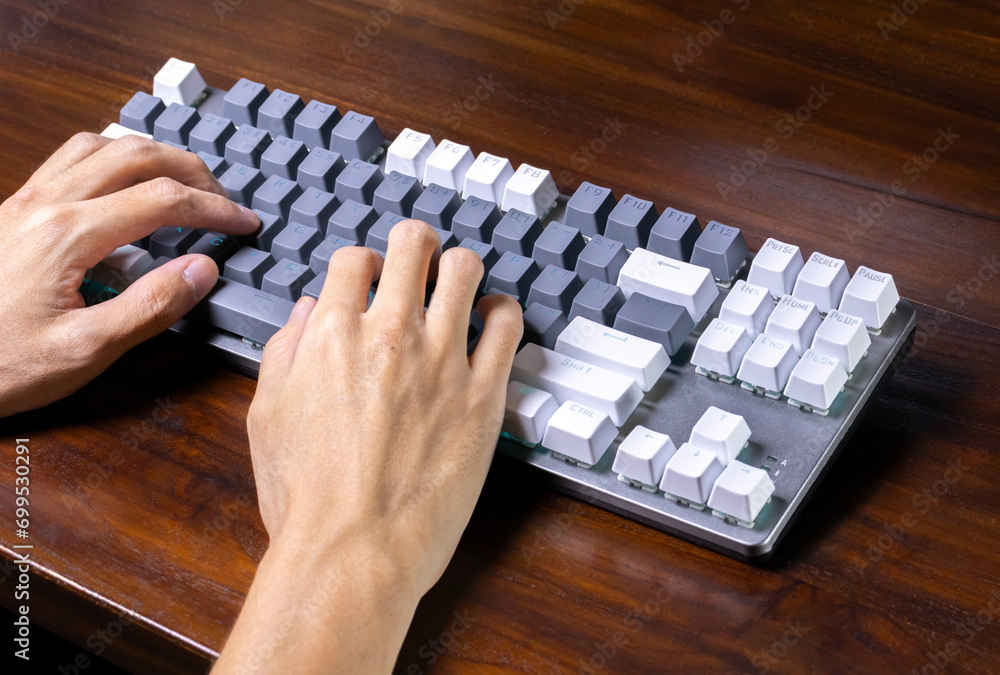 A modern mechanical keyboard and hands on a wooden table. After some edits. A modern mechanical keyboard and hands on a wooden table. After some edits.