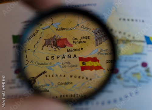 map of spain put in a magnifying glass with its flag flying photo