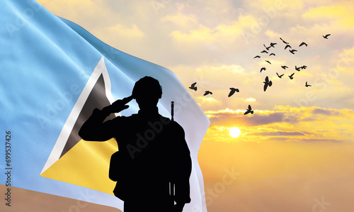 Silhouette of a soldier with the Saint Lucia flag stands against the background of a sunset or sunrise. Concept of national holidays. Commemoration Day.