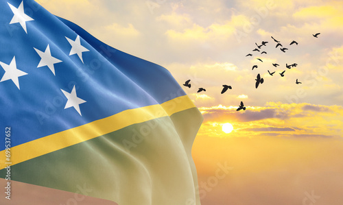 Fotografie Waving flag of Solomon Islands against the background of a sunset or sunrise