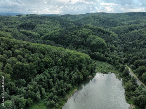 jezioro o przezroczystej wodzie pośród lasu oraz odbijające niebo, ekologiczny ekosystem, czyste powietrze, czysta woda, świeże powietrze, las oraz woda 