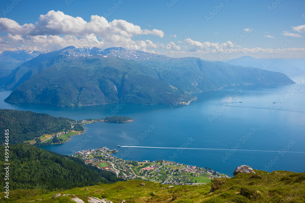 A panorama view from the summit of Raudmelen peak overlooking the town of Balestrand, Norway and Sognefjorden during a summer morning.