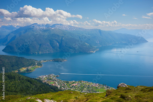 A panorama view from the summit of Raudmelen peak overlooking the town of Balestrand, Norway and Sognefjorden during a summer morning.