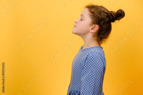 Profile side view of happy preteen girl do deep breath enjoy fresh air or dreaming fill with energy feeling healthy good concept, posing isolated over plain yellow studio background with copy space photo