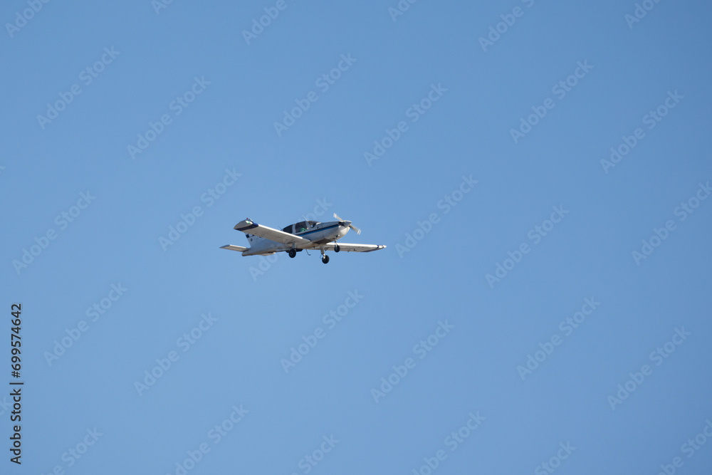 Light single-engine aircraft is in blue sky Light single-engine aircraft is in blue sky