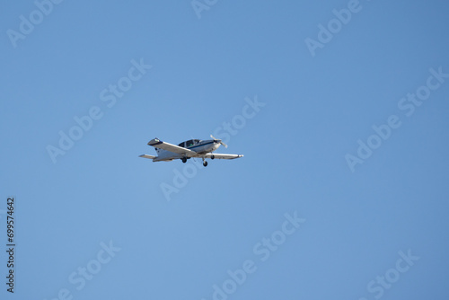 Light single-engine aircraft is in blue sky