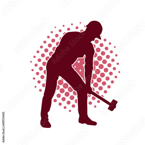 Silhouette of a worker in action pose using his sledge hammer tool.
