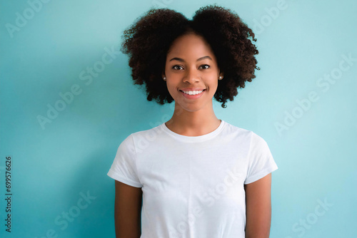 Portrait einer jungen schwarzen Frau mit Afro-Look und weißem T-Shirt vor neutralem blauen Hintergrund photo