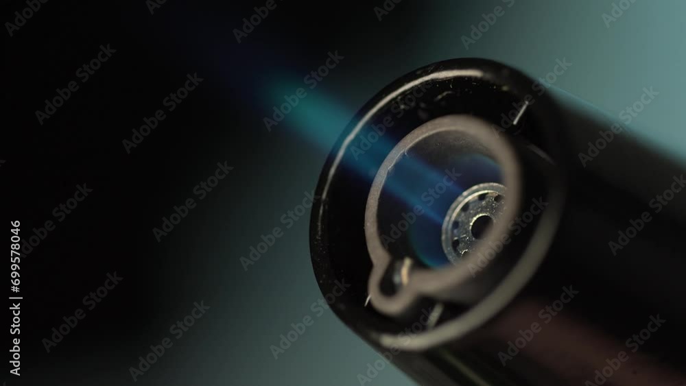 Butane Torch Lighter emits a Blue Flame. Macro shot, Shallow DOF. Butane Torch Lighter emits a Blue Flame. Macro shot, Shallow DOF.