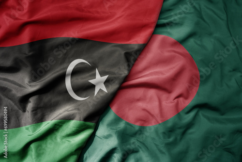 big waving national colorful flag of bangladesh and national flag of libya .